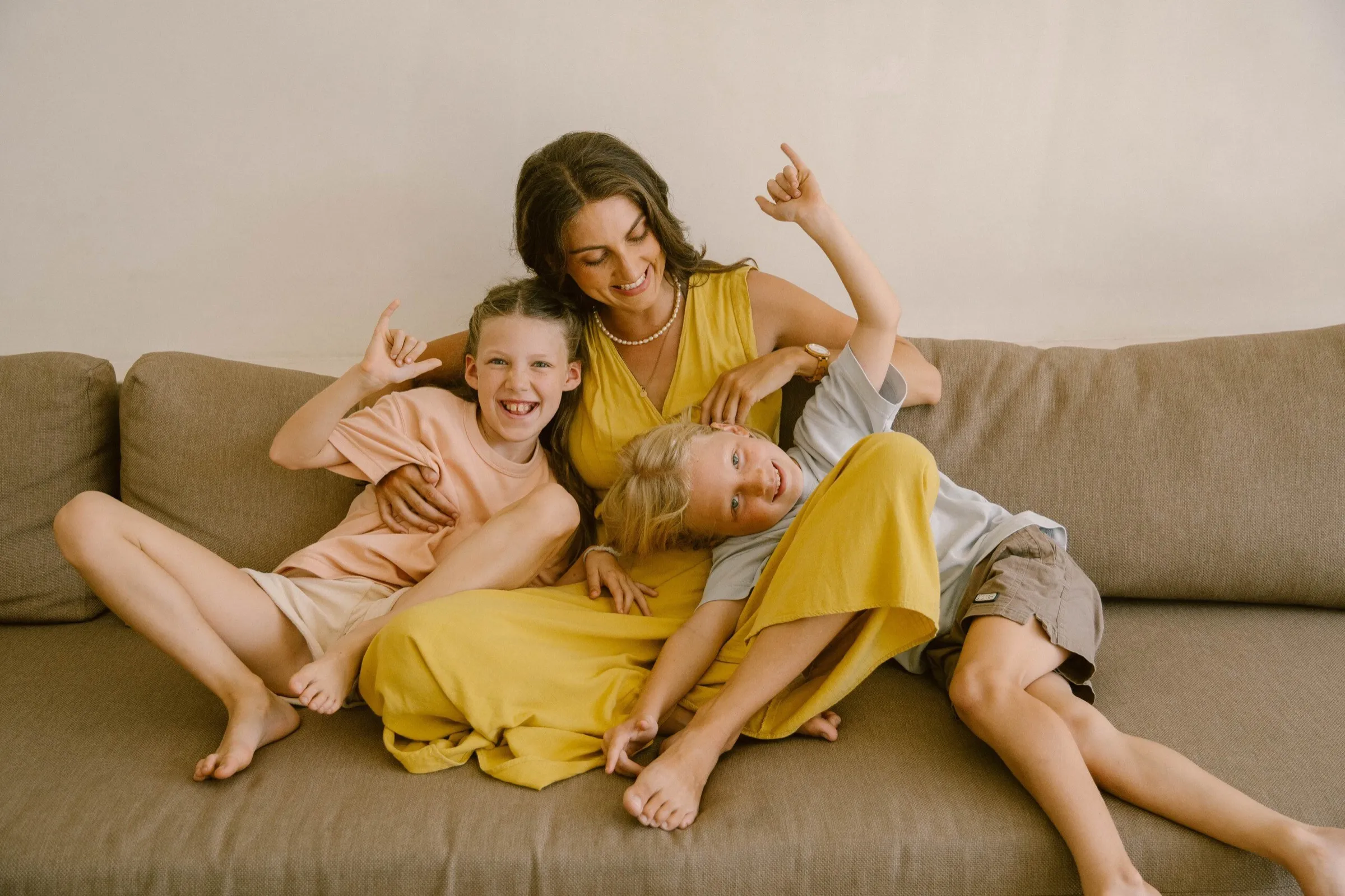 Kristin laughing on a sofa with her two older children